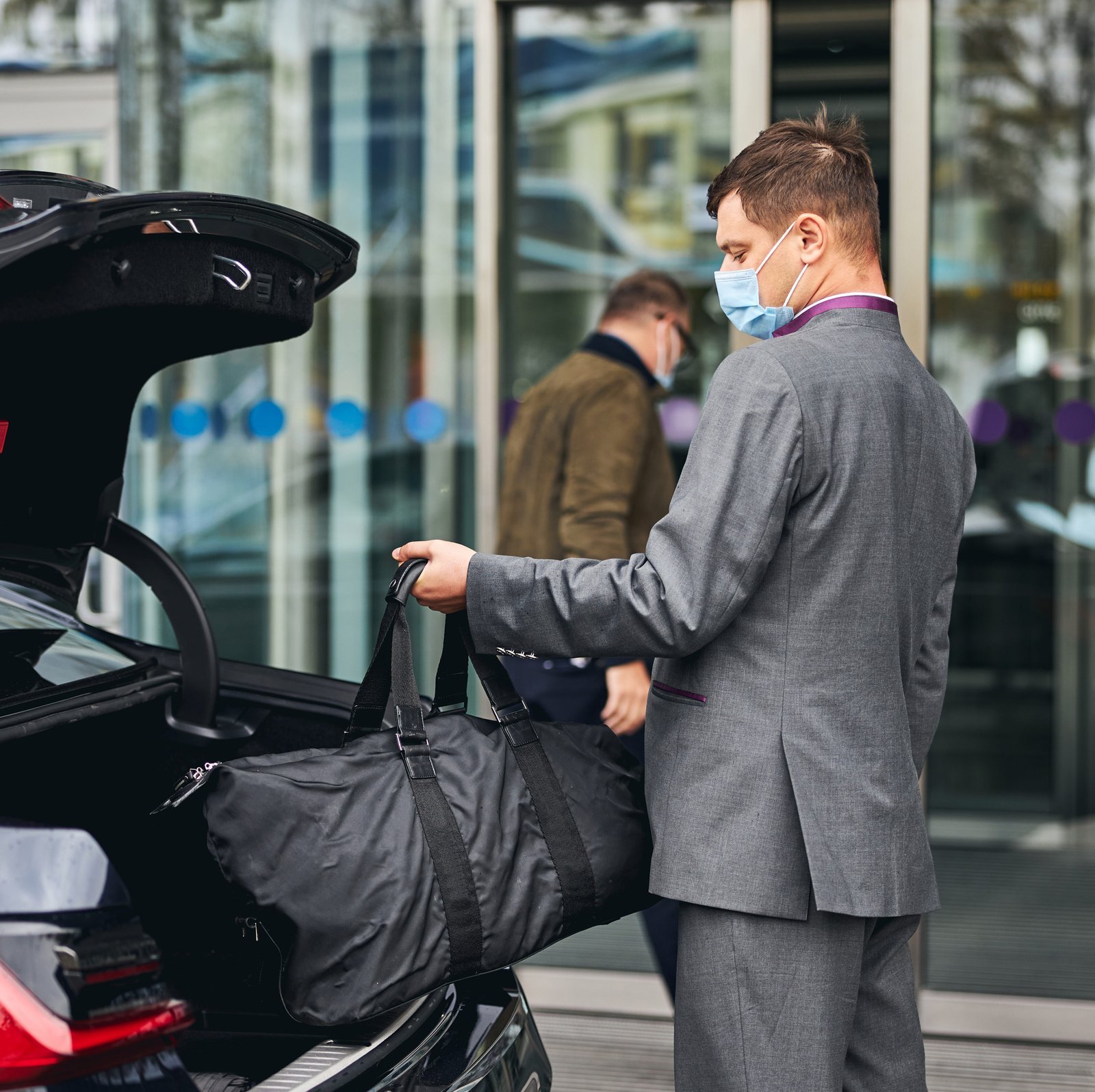 driver-helping-his-passenger-with-his-luggage-e1697098049664.jpg